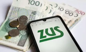 Złotówki i monety na tle ekranu telefonu z logo ZUS. Sprawdzanie opiekun medyczny zarobki.