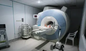 Pacjent leży na stole do rezonansu magnetycznego, gotowy na badanie MR.