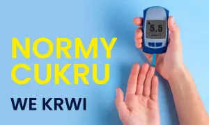 Glukoza norma: 5.5 mmol/L. Dłoń trzyma glukometr, pokazujący wynik pomiaru cukru we krwi.