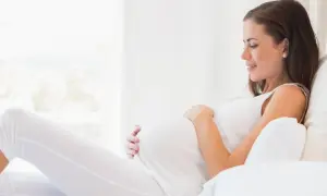 Kobieta w ciąży, która martwi się o konflikt serologiczny, odpoczywa w jasnym pokoju.