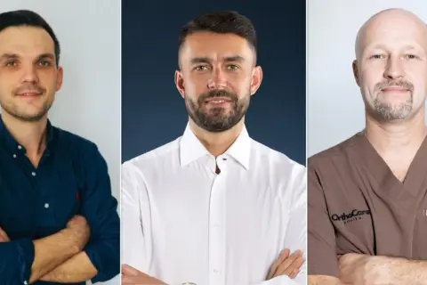 Trzech lekarzy: ortopeda w granatowej koszuli, chirurg w białej koszuli i lekarz w brązowym uniformie.