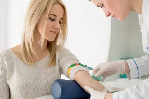 Pielęgniarka pobiera krew od pacjentki. Wyniki badań wskazują na rdw-sd podwyższone, co może wymagać dalszej diagnostyki.