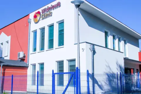 Nowoczesny budynek kliniki Wiśniowa Clinic w Zielonej Górze z niebieskim ogrodzeniem.