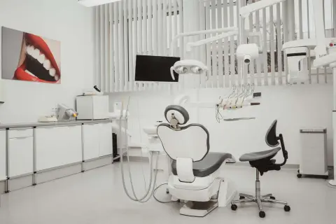 Nowoczesny gabinet stomatologiczny z fotelem, unitem i obrazem ust.