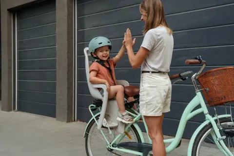 Mama i dziecko dają sobie piątkę przed rowerową wycieczką. To idealny sposób na spędzenie 5 dni urlopu opiekuńczego.