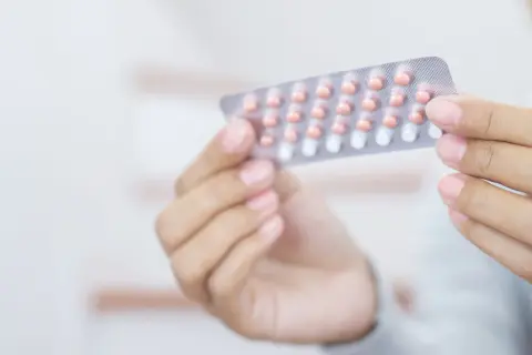 Dłoń trzyma blister z tabletkami antykoncepcyjnymi. Wiele osób szuka informacji o tabletki antykoncepcyjne nazwy.