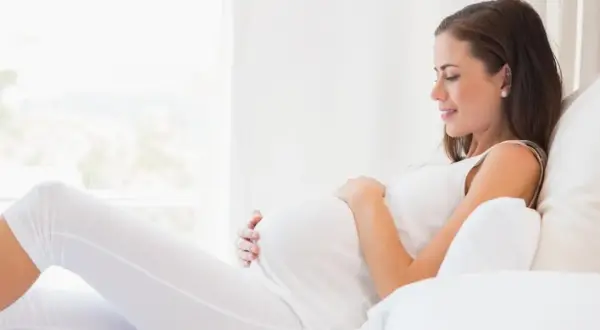 Kobieta w ciąży, która martwi się o konflikt serologiczny, odpoczywa w jasnym pokoju.